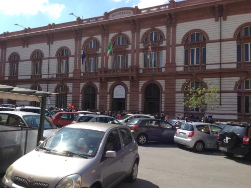 a large building with cars parked in front of it at Casa Mojito in Sassari