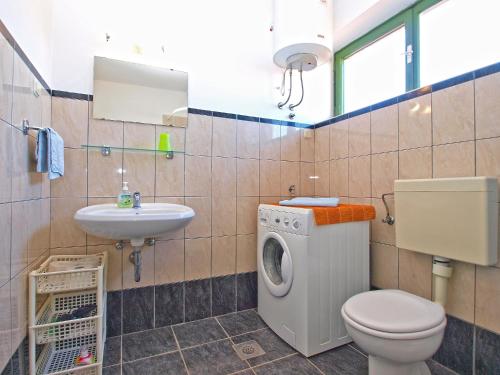 ein Badezimmer mit Toilette, Waschbecken und Waschmaschine in der Unterkunft Apartments Duilija 1301 in Barbariga