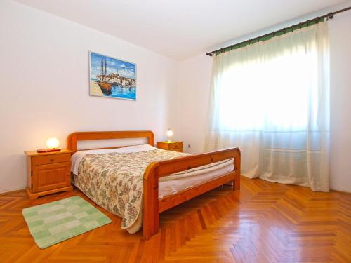 ein Schlafzimmer mit einem Bett und einem großen Fenster in der Unterkunft Apartments Duilija 1301 in Barbariga