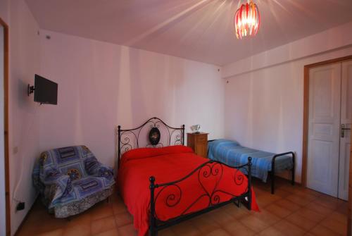 a bedroom with a bed with a red comforter at Vulcanoconsult Appartamenti Spiaggia in Lipari