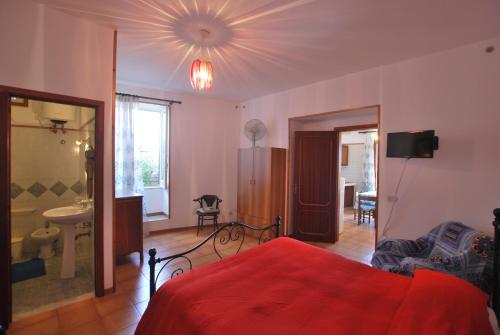 a bedroom with a red bed and a bathroom at Vulcanoconsult Appartamenti Spiaggia in Lipari