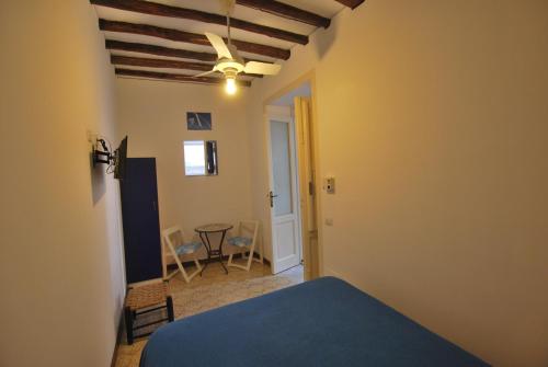 a bedroom with a blue bed and a table at Vulcanoconsult Appartamenti Spiaggia in Lipari