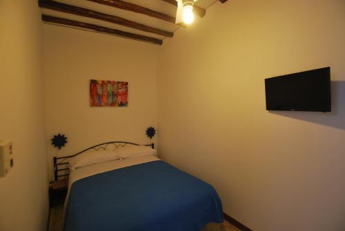 a bedroom with a bed and a flat screen tv at Vulcanoconsult Appartamenti Spiaggia in Lipari