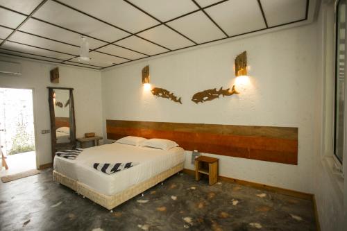 a bedroom with a bed and two horses on the wall at Rasdhoo Island Inn Beachfront in Rasdu