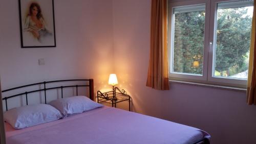 een slaapkamer met een bed en een raam bij Apartment Leonardo in Medulin