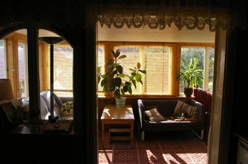 a living room with a couch and a table and windows at Pokoje Gościnne Nowy Świat in Supraśl