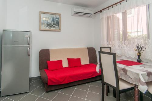 a living room with a red couch and a table at Zora Apartment in Mali Lošinj