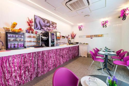 a dining room with pink chairs and a counter at Hotel Relais Dei Papi in Rome