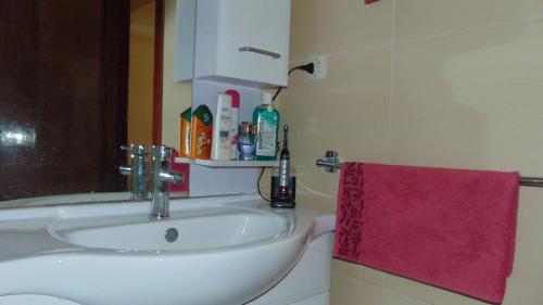 a bathroom with a sink and a red towel at Suite Apartment Fawzi in Agadir