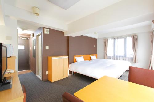 FLEXSTAY INN Shirogane في طوكيو: غرفة فندق بسرير وتلفزيون