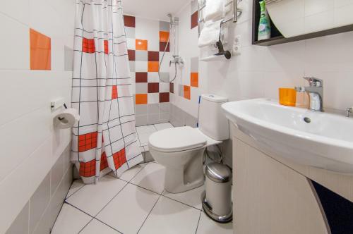 a white bathroom with a toilet and a sink at Apart-Hotel Powder in Kirovsk