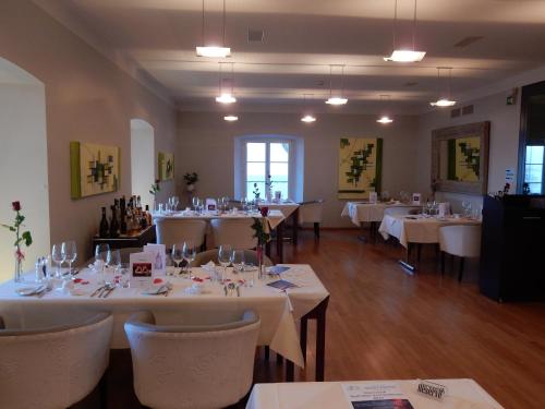 a dining room with white tables and white chairs at Schloss Wartensee in Rorschacherberg