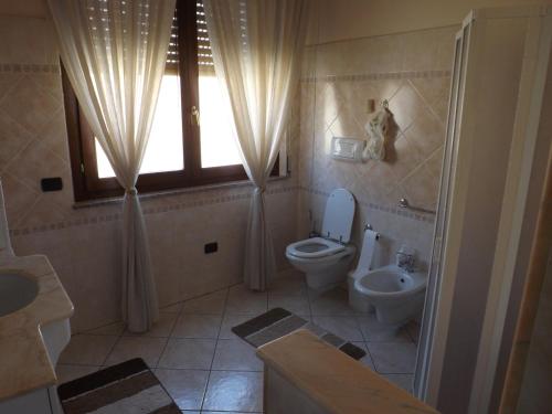 シニスコーラにあるB&B Le Grazieのバスルーム(トイレ、洗面台付)、窓が備わります。