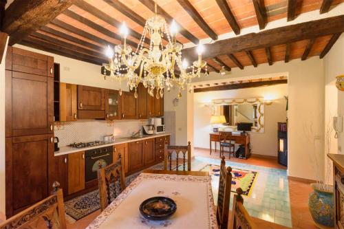 eine Küche mit einem Esstisch und einem Kronleuchter in der Unterkunft CASA DI CHIARILU' in Cortona