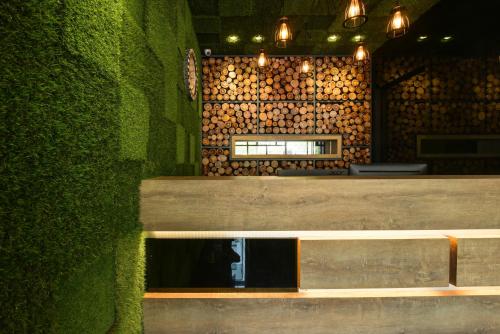a bench in a restaurant with a green wall at Laman Green The Boutique Hotel in Shah Alam