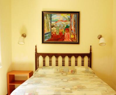ポルトボウにあるHotel Comodoroのベッドルーム1室(壁に絵画が描かれたベッド1台付)