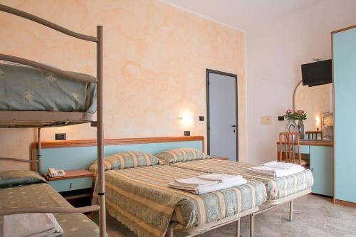 a bedroom with a bunk bed and a chair at Hotel Vernel in Rimini