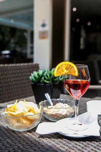 a glass of wine sitting on top of a table at Hotel Vernel in Rimini