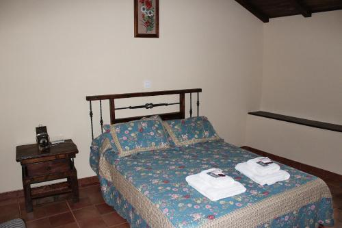 a bedroom with a bed with two towels on it at Casa Rural El Quinto y Medio in Valdelacasa de Tajo