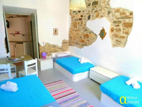 a small room with two beds and a table at Apano Vrysi in Tinos