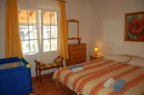 a bedroom with a bed and a dresser and a window at Casa el Anden in El Cedro