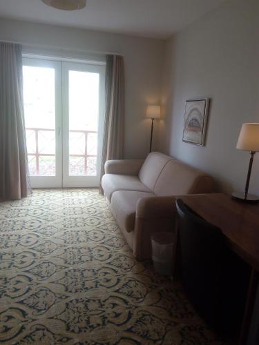 a living room with a couch and a large window at Montra Odder Parkhotel in Odder