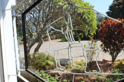 a metal chair sitting in the middle of a garden at Riviera Garden in Antananarivo