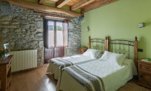 una camera con letto e parete in pietra di Casa rural Restaurante Aranburu a Zestoa