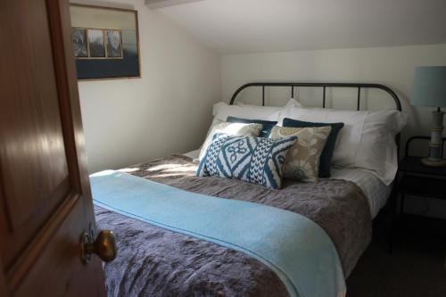 Un dormitorio con una cama con almohadas. en Pardlestone Farm Cottages, en Kilve