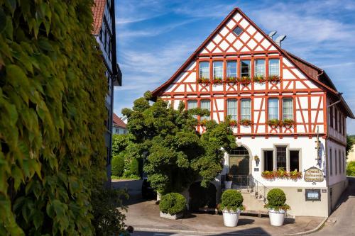 an orange and white house with potted plants at Bürgerbräu in Überlingen