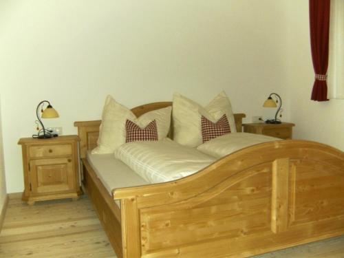 a bedroom with a wooden bed with two night stands at Leirerfeld in Alpbach