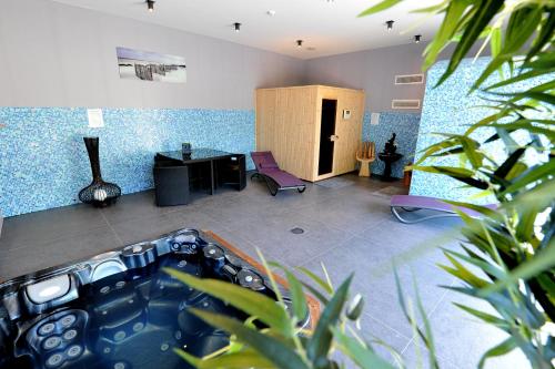 Habitación con escritorio y habitación con paredes azules. en Logis- Hôtel Spa Restaurant l'Epicurial en Saint-Pey-de-Castets