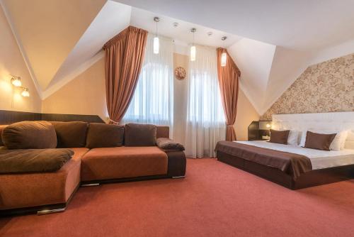 Kiev 365 Park Hotel في كييف: غرفة معيشة مع أريكة وسرير