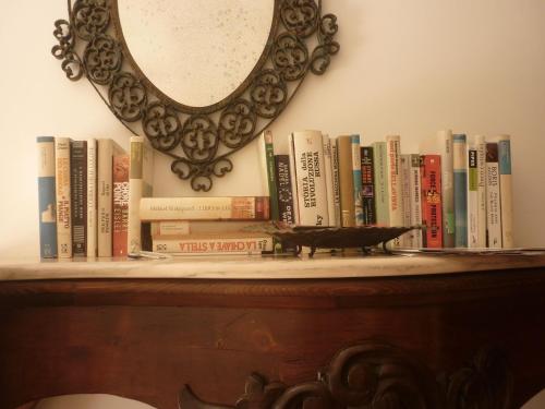 a book shelf with books on it with a mirror at B&B Villa Giuliana in Arnesano