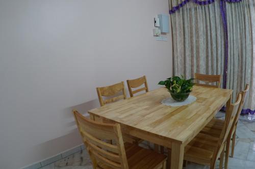 un tavolo in legno con sedie e una pianta in vaso. di Taiping Cozy Homestay a Taiping