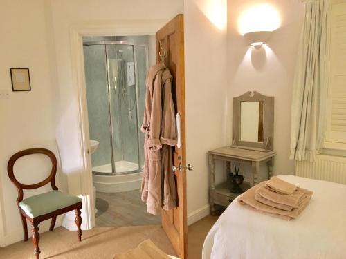 a bedroom with a shower and a bed and a chair at SmallBrook Cottage in Broadway