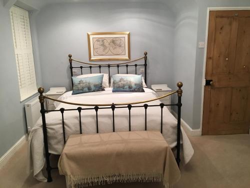 a bedroom with a bed with a wrought iron frame at SmallBrook Cottage in Broadway