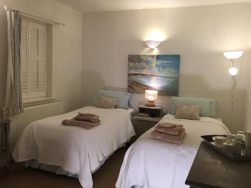 a room with two beds with towels on them at SmallBrook Cottage in Broadway