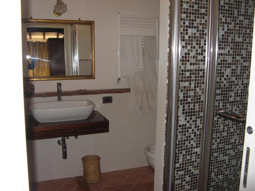 ルッカにあるLa TERRAZZA fra le TORRIのバスルーム(洗面台、鏡、トイレ付)
