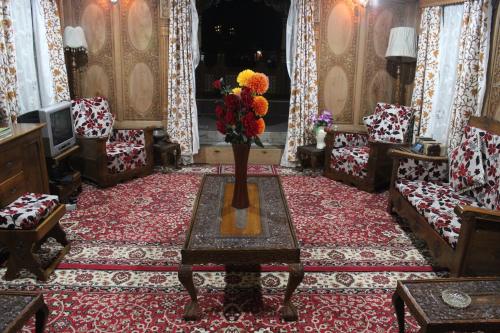 a room with chairs and a vase of flowers on a table at House Boat New Lucifer in Srinagar