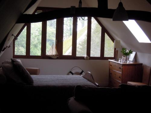 a bedroom with a large window with a bed and a dresser at La Maison De Lalette in Gruchet-Saint-Siméon