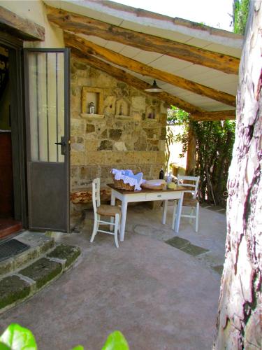 a patio with a table and chairs and a stone wall at Agriturismo "Borgo Madonna degli Angeli" - charming cottages in the gardens ! in Tocco da Casauria