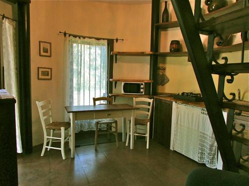 a kitchen with a table and chairs in a room at Agriturismo "Borgo Madonna degli Angeli" - charming cottages in the gardens ! in Tocco da Casauria