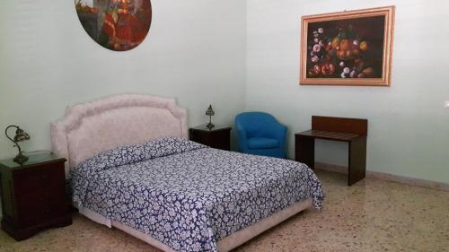 sypialnia z łóżkiem i niebieskim krzesłem w obiekcie Profumo di Sicilia w mieście Palermo