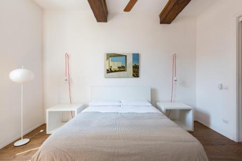 ローマにあるVicoloft Vicoloのベッドルーム1室(大型ベッド1台、白いテーブル2台付)