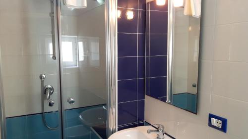 een badkamer met een douche, een wastafel en een spiegel bij Profumo di Sicilia in Palermo