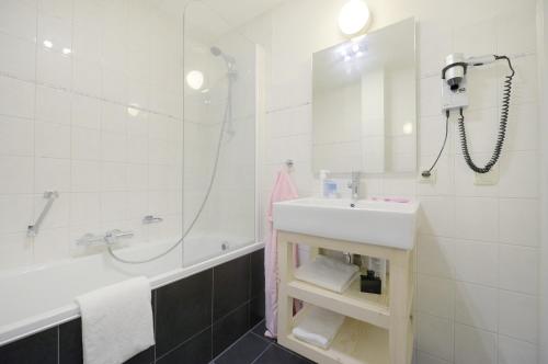 a bathroom with a sink and a shower and a tub at Center Parcs Sandur Emmen in Emmen