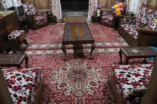 a room with a red rug with a table and chairs at House Boat New Lucifer in Srinagar