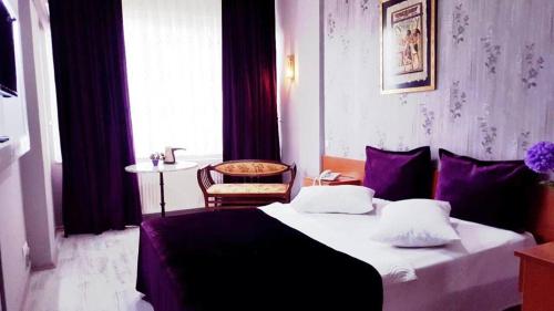 a bedroom with a bed and a chair and a window at Masal Otel in Kocaeli