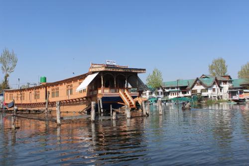 a boat sitting on the water next to houses at House Boat New Lucifer in Srinagar